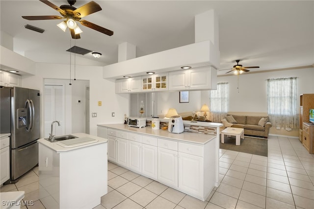 kitchen with a center island with sink, visible vents, light tile patterned flooring, a sink, and stainless steel fridge with ice dispenser