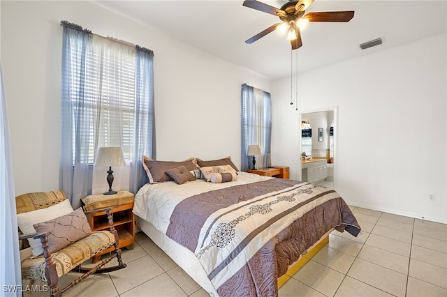 bedroom featuring light tile patterned floors, baseboards, visible vents, a ceiling fan, and ensuite bath