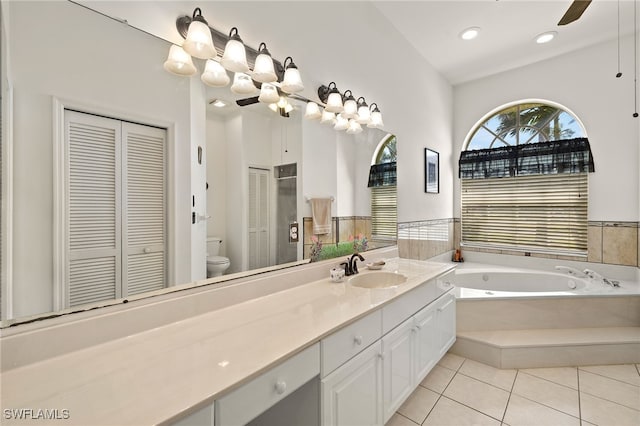 full bathroom featuring a closet, toilet, tile patterned floors, vanity, and a bath