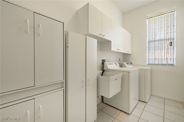 washroom featuring light tile patterned floors, independent washer and dryer, cabinet space, and baseboards