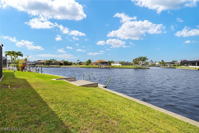 view of dock with a lawn and a water view