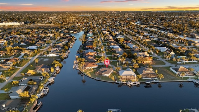 aerial view at dusk with a residential view and a water view