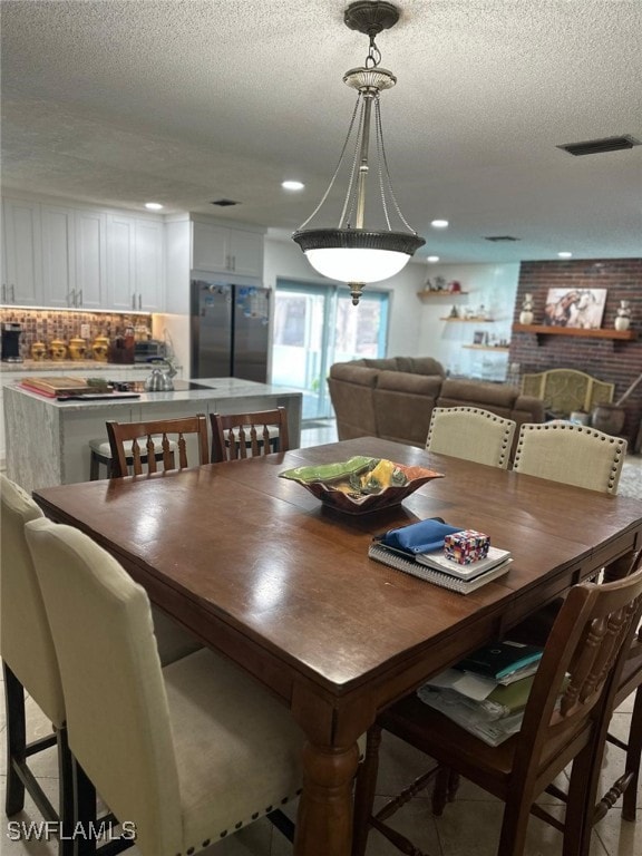 dining room featuring recessed lighting, visible vents, and a textured ceiling