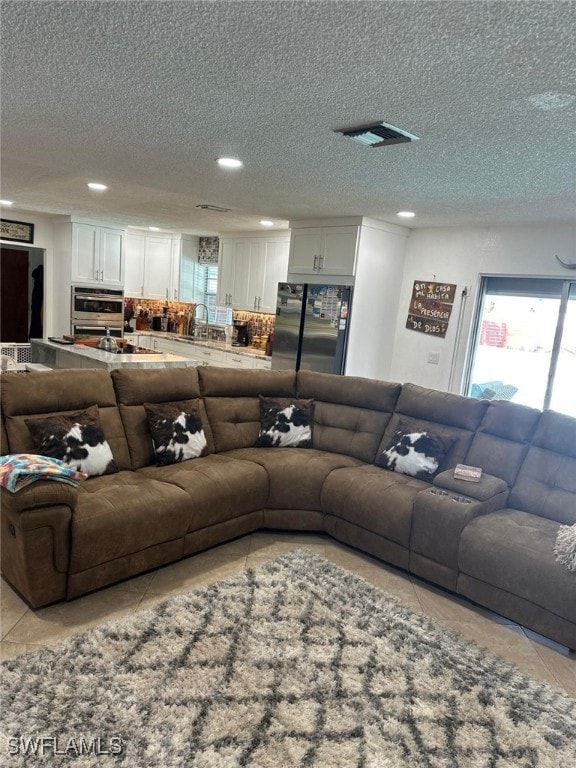 living room featuring light tile patterned floors, visible vents, and recessed lighting