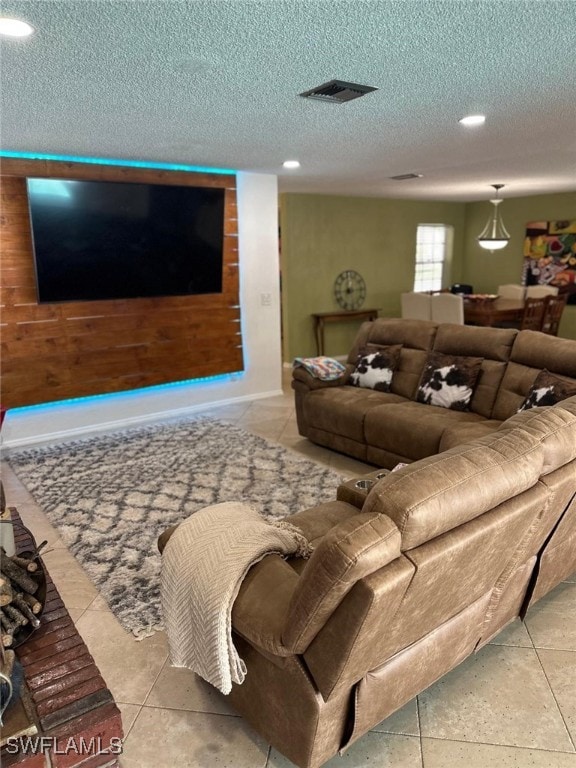 living area featuring visible vents, wood walls, and a textured ceiling