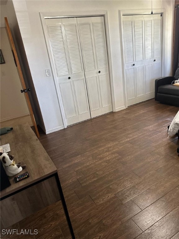 bedroom featuring two closets and dark wood-style floors