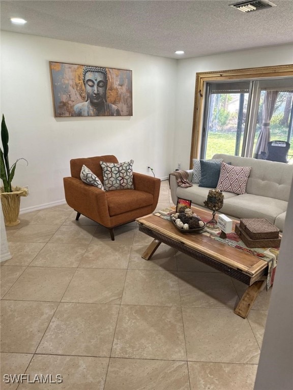 living area with visible vents, baseboards, light tile patterned floors, recessed lighting, and a textured ceiling