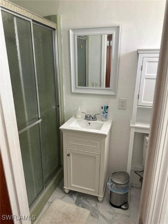 bathroom featuring vanity, marble finish floor, and a stall shower