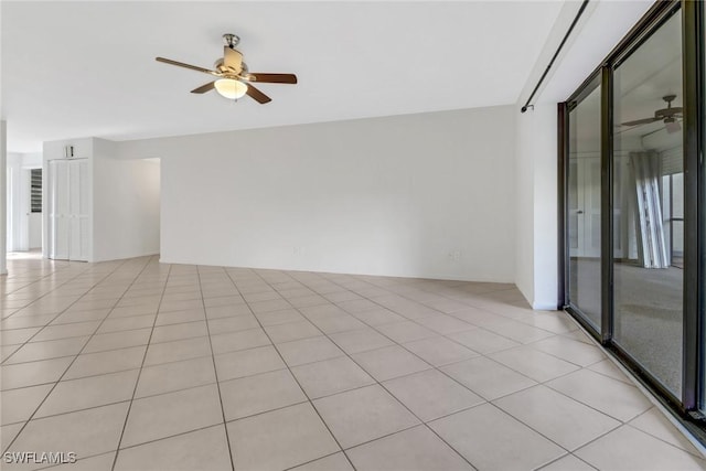 empty room with light tile patterned floors and a ceiling fan