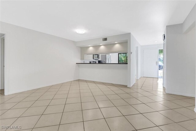 unfurnished living room featuring light tile patterned flooring and visible vents