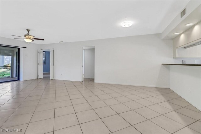 spare room featuring light tile patterned floors, visible vents, and a ceiling fan