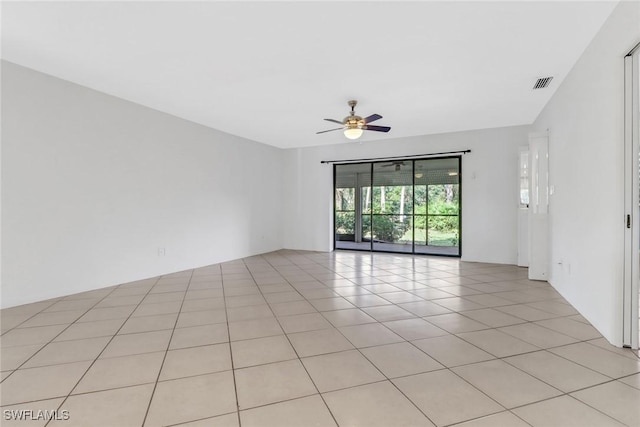 empty room with light tile patterned floors, a ceiling fan, and visible vents