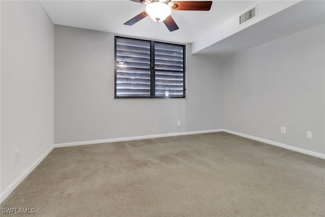 carpeted empty room featuring visible vents, a ceiling fan, and baseboards