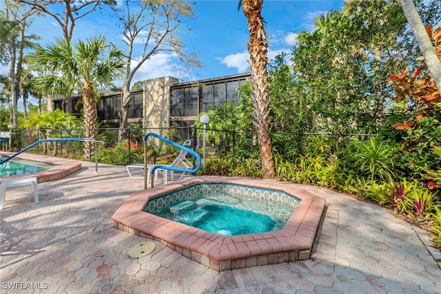 view of pool featuring a patio area, an in ground hot tub, and fence