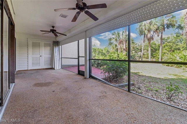 unfurnished sunroom with visible vents and a ceiling fan