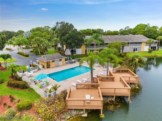 community pool with a patio area, a fenced backyard, and a deck with water view