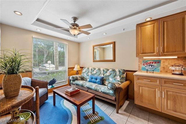 sitting room with light tile patterned floors, wainscoting, ceiling fan, a tray ceiling, and recessed lighting