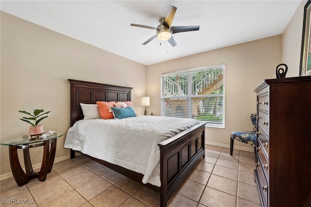 bedroom featuring ceiling fan, baseboards, and light tile patterned floors