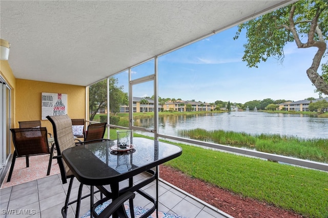 sunroom / solarium featuring a water view