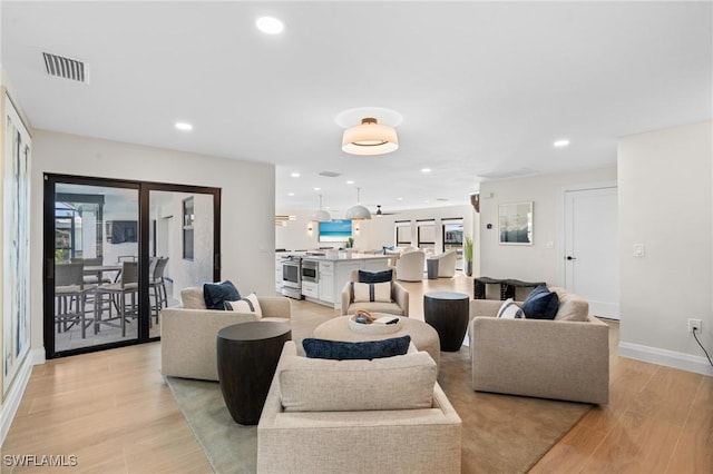 living area with recessed lighting, visible vents, baseboards, and light wood-style floors