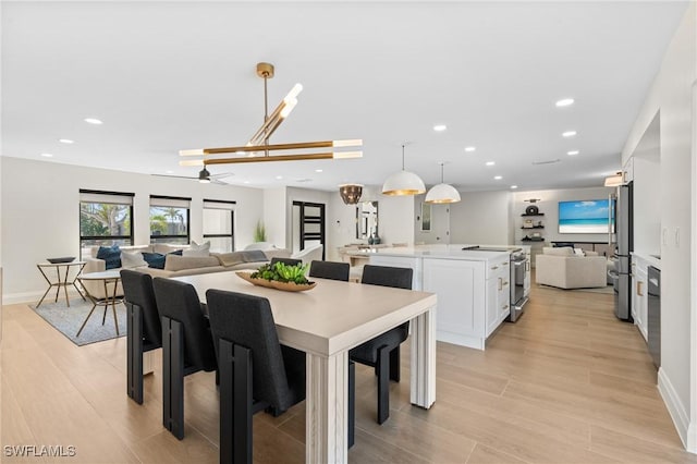 dining area with light wood finished floors, recessed lighting, baseboards, and a ceiling fan