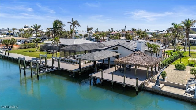 dock area with boat lift, a residential view, glass enclosure, and a water view