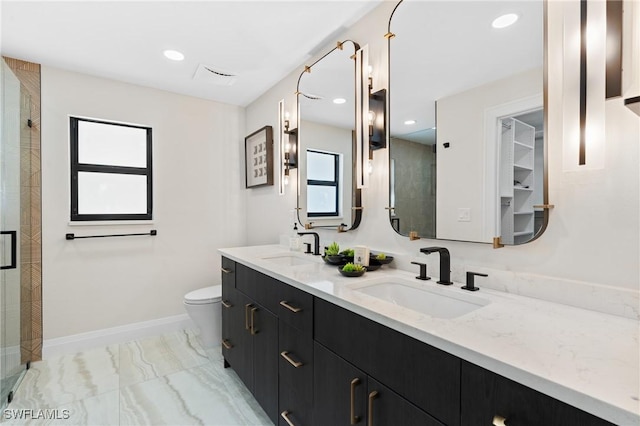 bathroom with marble finish floor, a stall shower, baseboards, and a sink