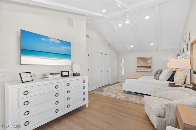 bedroom featuring light wood finished floors, visible vents, baseboards, beam ceiling, and high vaulted ceiling