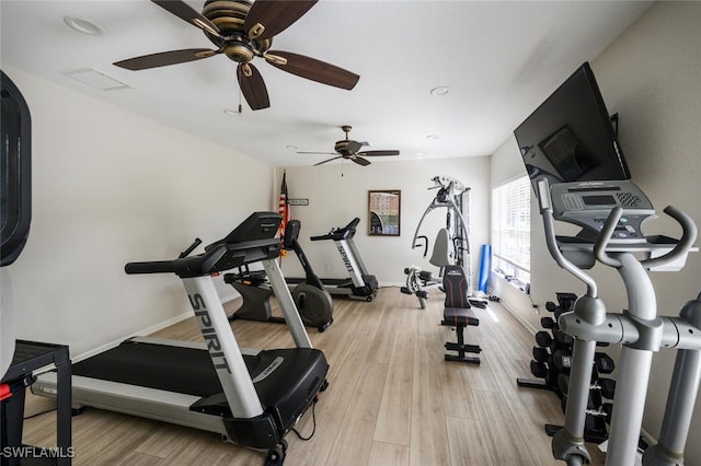 exercise area with light wood-style flooring and baseboards