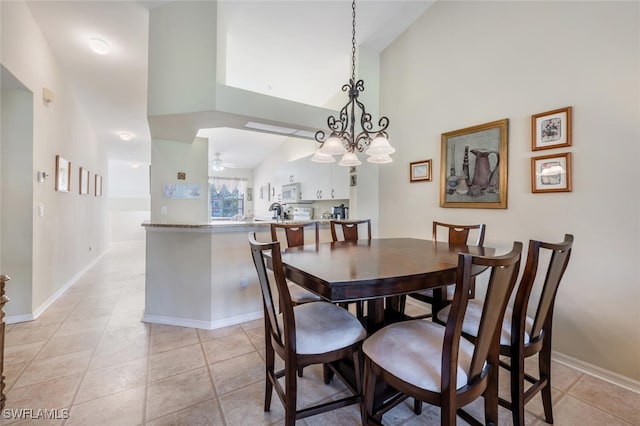 dining space with high vaulted ceiling, ceiling fan, baseboards, and light tile patterned floors