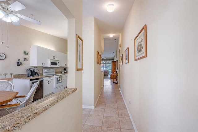 corridor with baseboards and light tile patterned floors