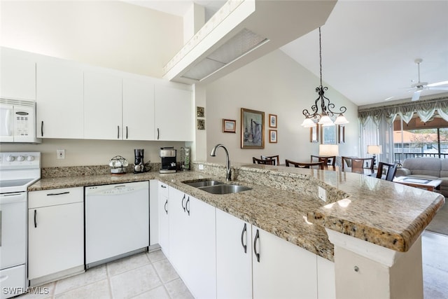 kitchen featuring a peninsula, white appliances, a sink, a ceiling fan, and open floor plan