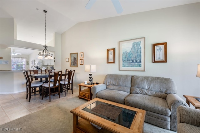 living room featuring light tile patterned flooring, vaulted ceiling, baseboards, and ceiling fan with notable chandelier