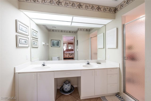 full bath featuring double vanity, a stall shower, toilet, and a sink