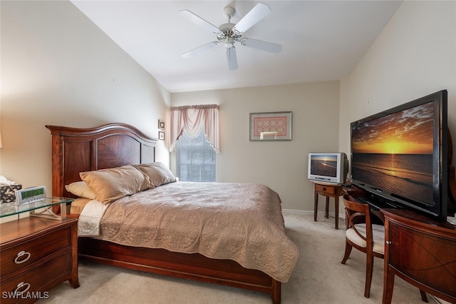 bedroom featuring light carpet, a ceiling fan, and baseboards