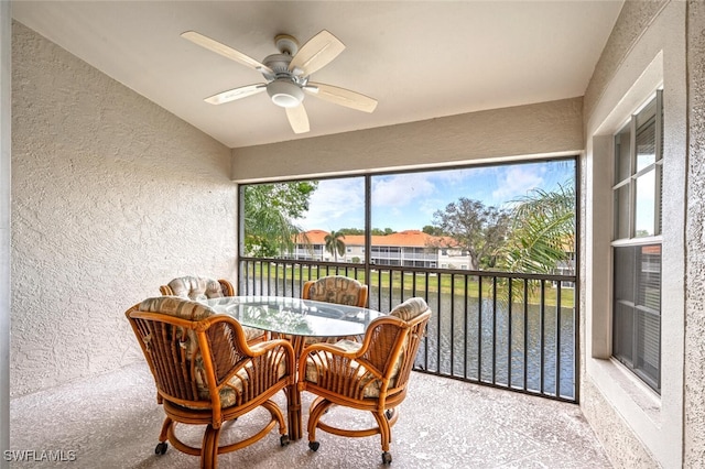 sunroom / solarium with a water view and a ceiling fan