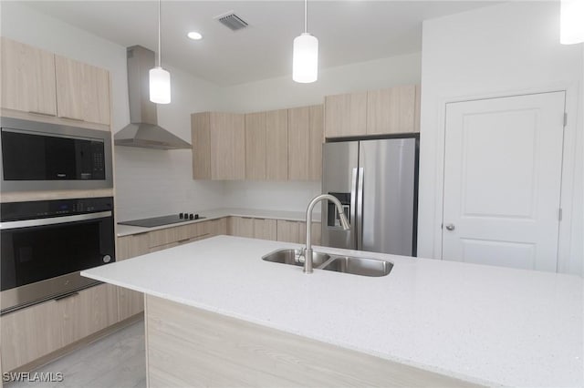 kitchen featuring modern cabinets, appliances with stainless steel finishes, a sink, and light brown cabinetry