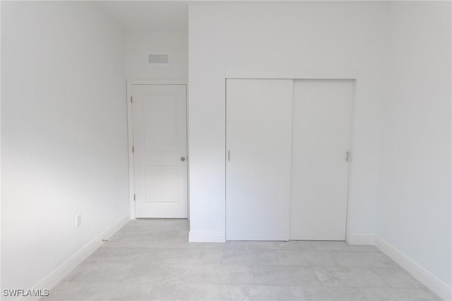 unfurnished bedroom featuring a closet, visible vents, and baseboards