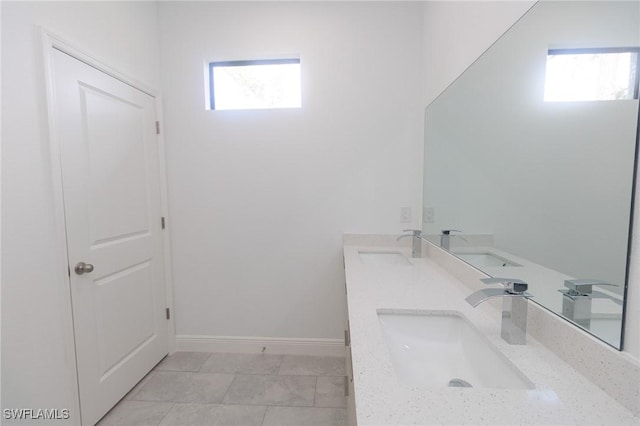 bathroom featuring a sink, baseboards, and double vanity