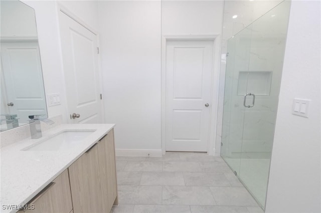 bathroom with baseboards, vanity, and a marble finish shower