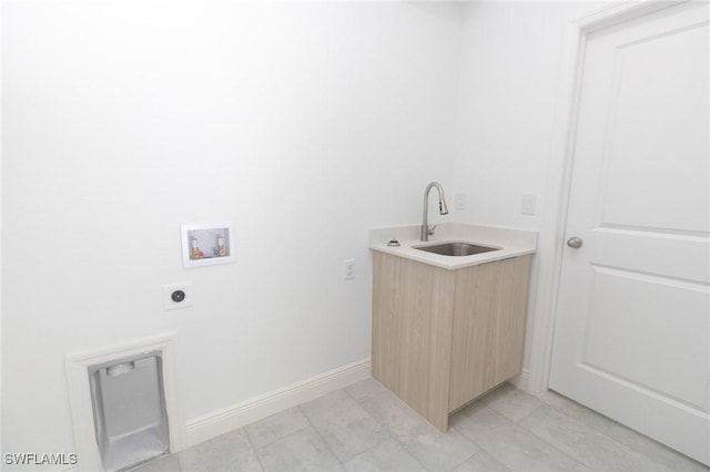 clothes washing area with hookup for an electric dryer, laundry area, washer hookup, a sink, and baseboards