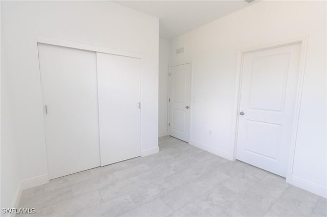 unfurnished bedroom with a closet, visible vents, and baseboards