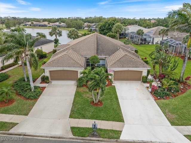 view of front facade featuring a tile roof, concrete driveway, a front lawn, and a water view