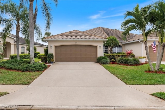 mediterranean / spanish-style home featuring a tile roof, a garage, and stucco siding