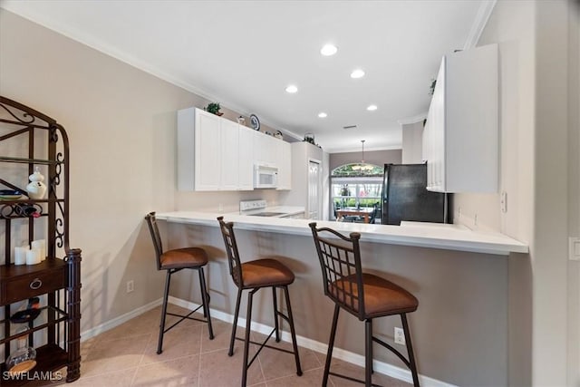 kitchen featuring ornamental molding, electric stove, freestanding refrigerator, light tile patterned floors, and white microwave