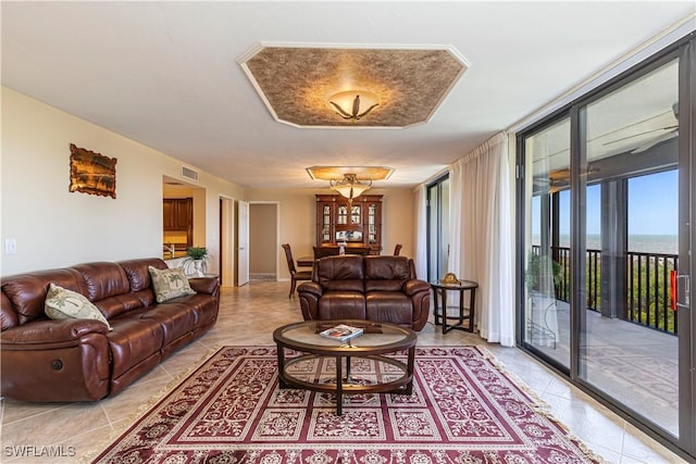 living room with visible vents, light tile patterned floors, and a water view