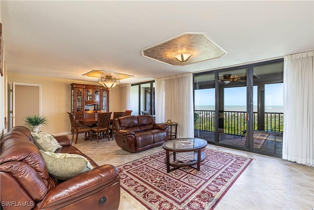 living room with light tile patterned floors, a water view, and baseboards