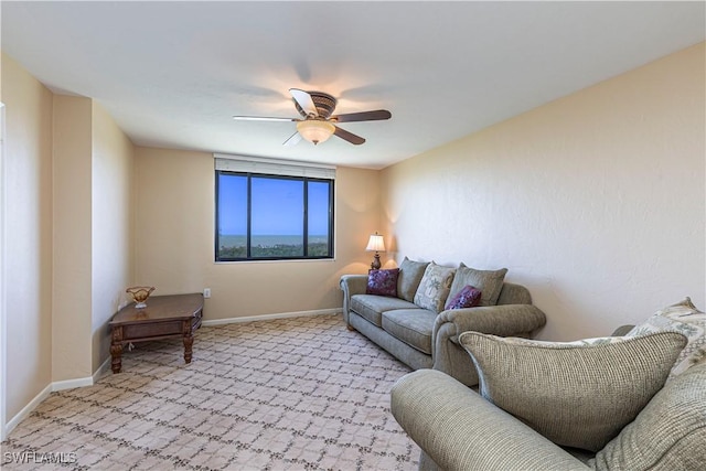 living room featuring baseboards, ceiling fan, and light colored carpet