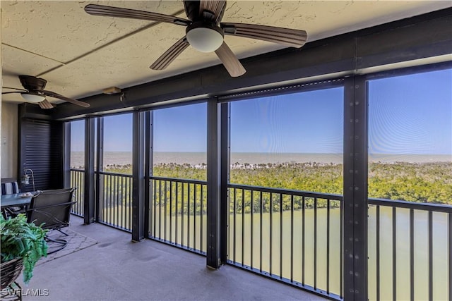 sunroom featuring a water view