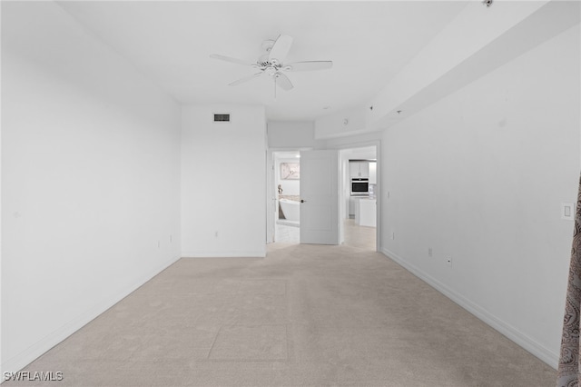 spare room featuring visible vents, baseboards, light colored carpet, and ceiling fan